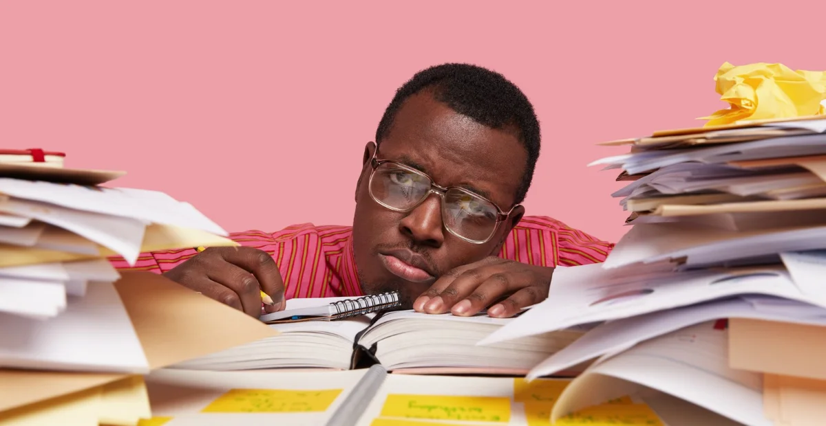 A stressed student surrounded by books, emphasizing the downsides of last-minute cramming before exams.